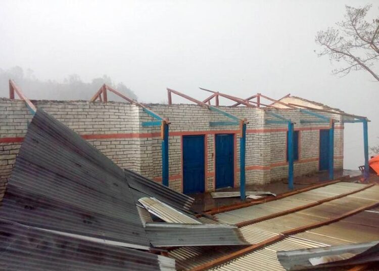विद्यालयको छानो हावाहुरीले उडाएपछि विद्यार्थी खेलमैदानमा पढ्दै